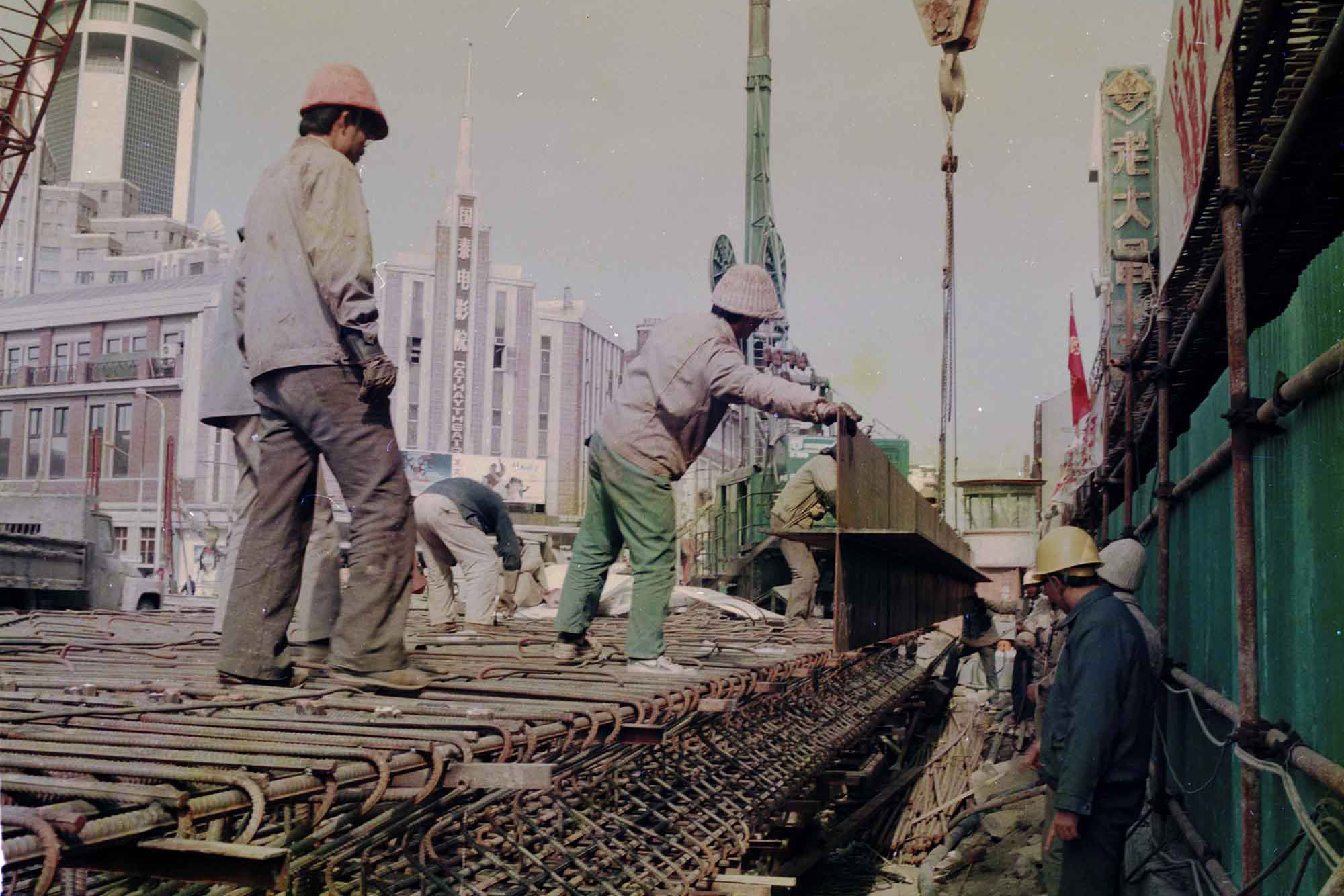 1992年，上海，淮海中路。工人们正在挖路，用于修建地铁（今陕西南路站附近）。陆杰 图