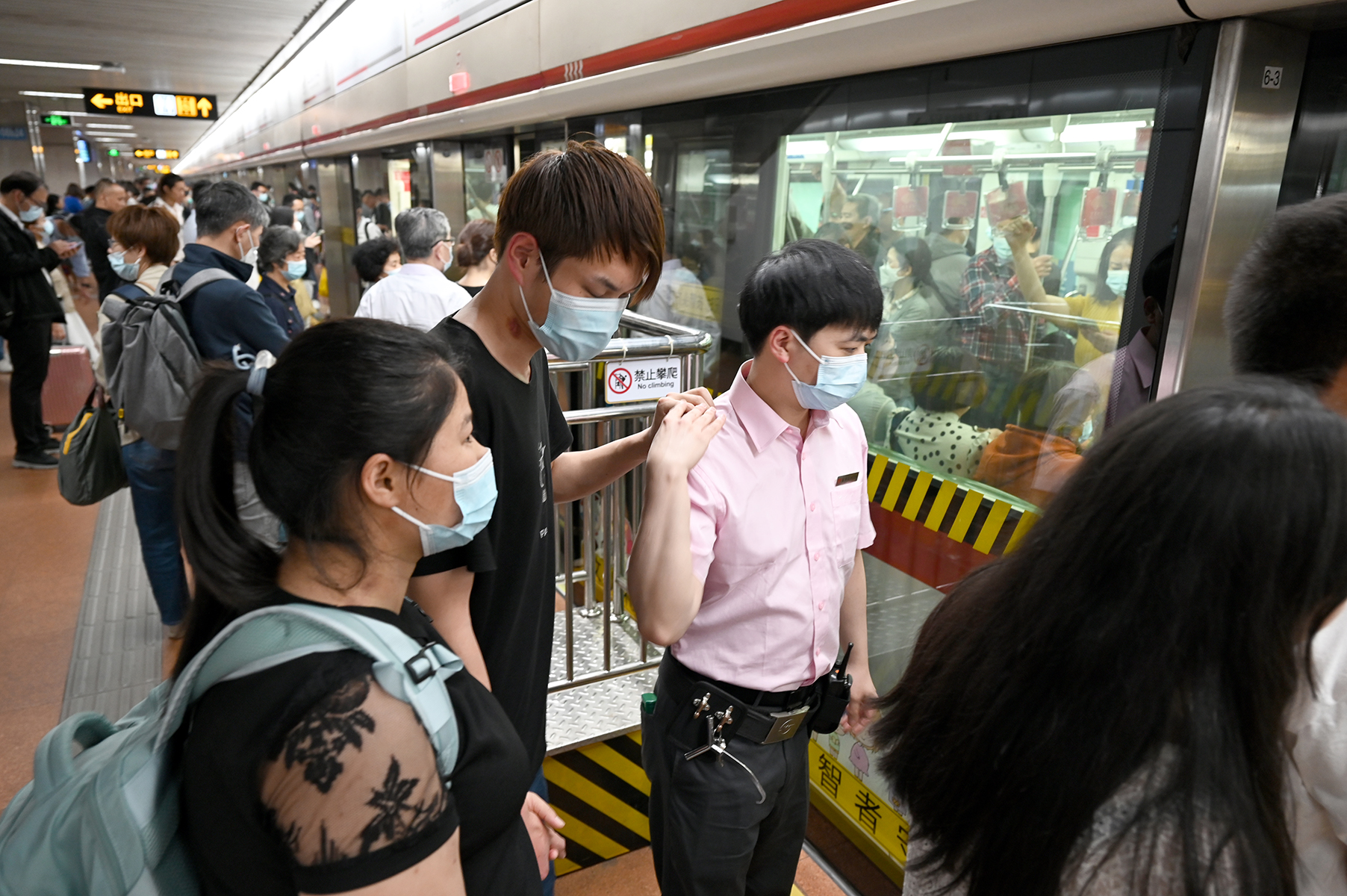 2023年5月25日，上海，地铁上海火车站站。一名地铁站台工作人员正在搀扶帮助一位盲人上车。澎湃新闻记者 吴栋 图
