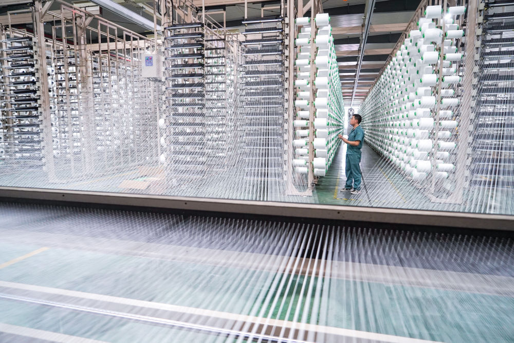 工人在位于苏州市吴江区盛泽镇的恒力集团博雅达纺织智能车间作业（2021年5月14日摄）。新华社记者 李博 摄