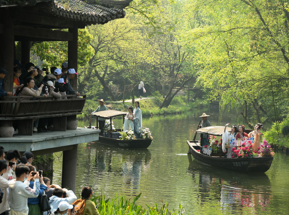 游客在杭州西溪湿地观看宋韵花朝节游船巡游(2023年4月2日摄)。新华社记者 翁忻旸 摄