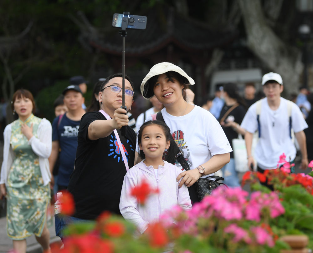 游客在杭州西湖断桥留影(2023年5月3日摄)。新华社记者 翁忻旸 摄