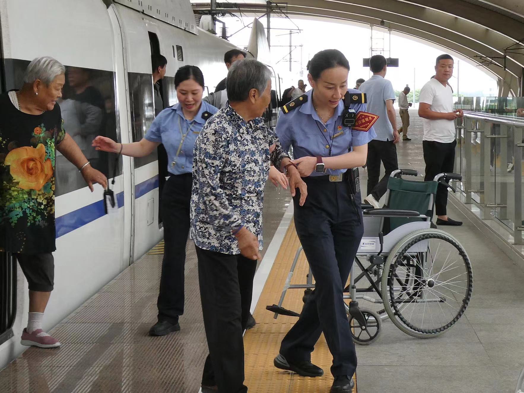工作人员搀扶旅客下车  中国铁路上海局 供图