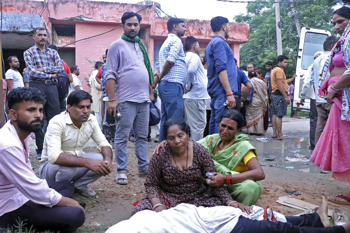 7月2日，在印度北方邦哈特勒斯地区，遇难者亲属在遇难者遗体旁哭泣。新华社/美联