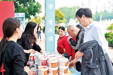重庆小面文化节上,工作人员给市民推荐重庆小面佐料。(资料图) 钟戈 摄