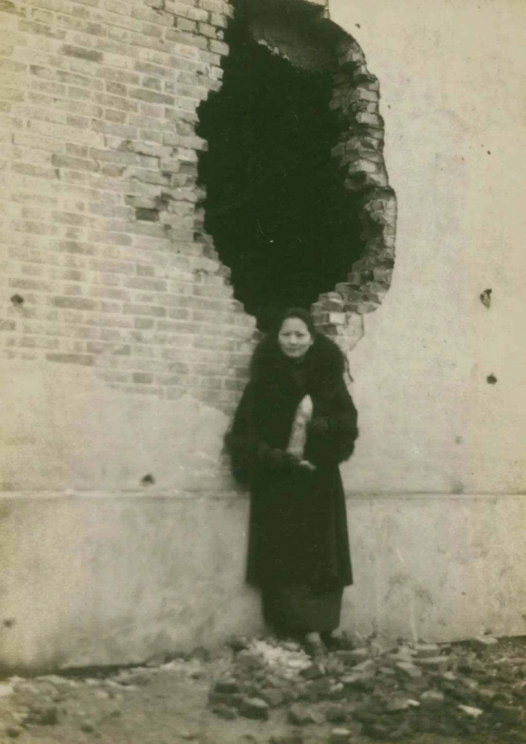 1932年,宋庆龄在真如前线慰问巡视战地时,手捧未爆炸的敌弹留影,以表抗战到底的决心