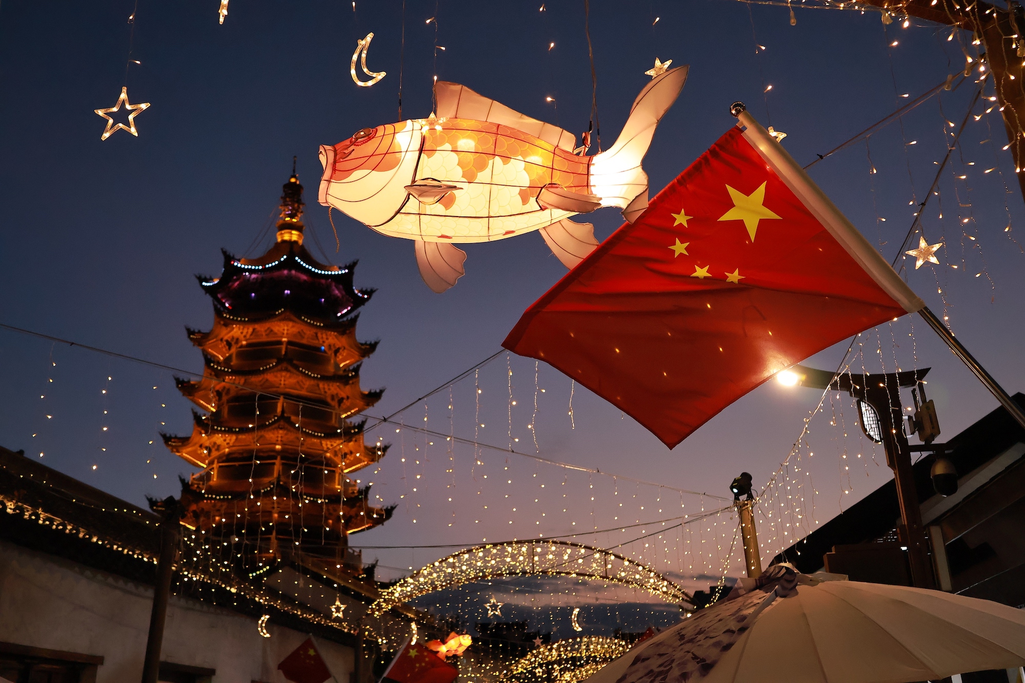 2025年10月8日,上海松江泗泾古镇,街道布置“国庆中秋双节”限定装扮,红旗飘扬,灯笼高挂。