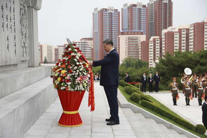 当地时间6月9日上午，正在朝鲜进行国事访问的中共中央总书记、国家主席习近平和夫人彭丽媛参谒中朝友谊塔。朝鲜劳动党总书记、国务委员长金正恩和夫人李雪主陪同。这是习近平整理花篮缎带。新华社记者 丁海涛 摄