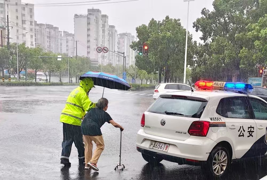 图为宝山分局刘行所民警护送因台风降雨被困在外的老人安全回家。/采访对象提供