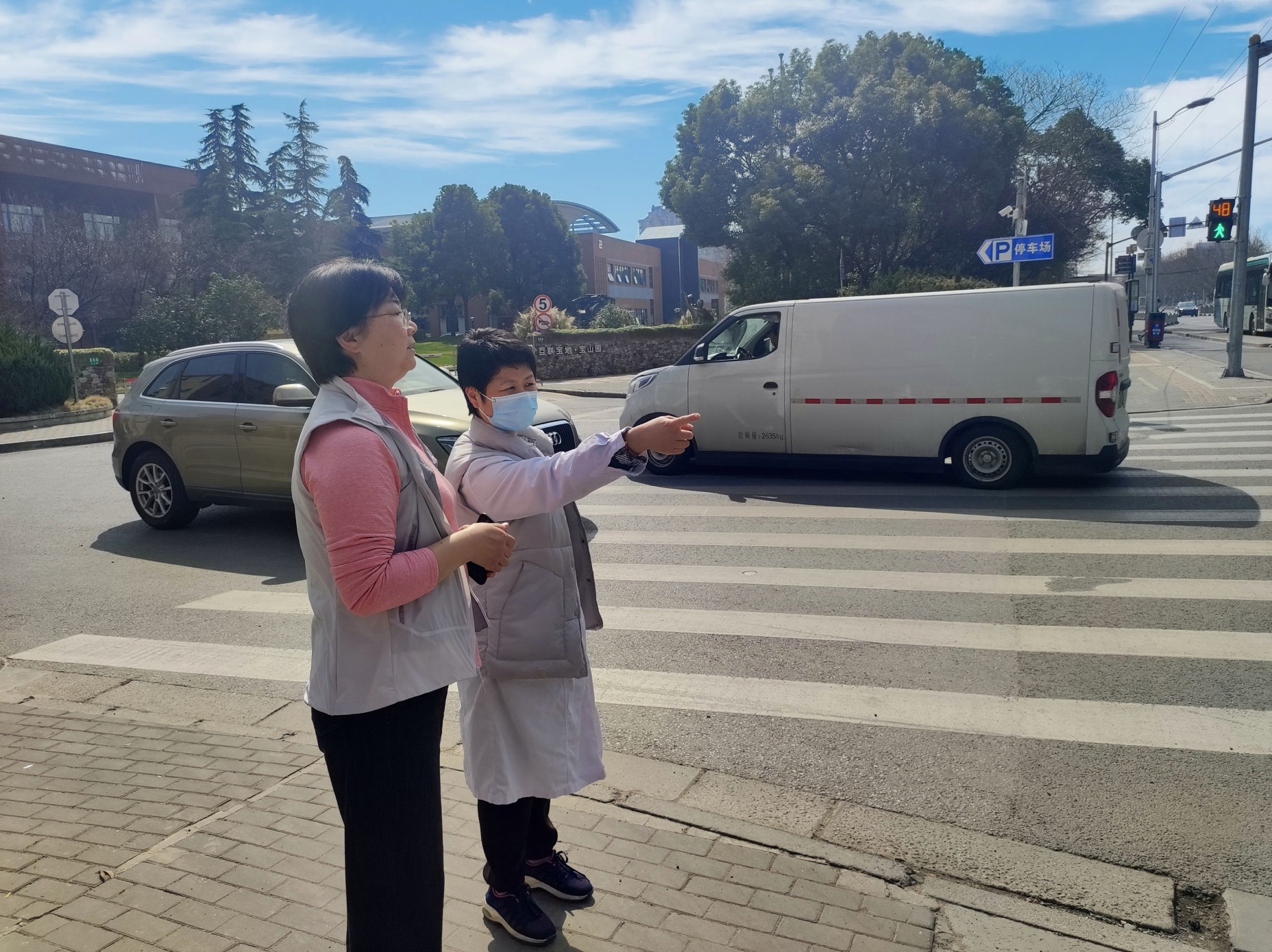 2023年2月,落组淞南镇政协委员工作站的戴红梅委员(右)在长江路、卫生科路路口调研交通信号灯时长设置情况