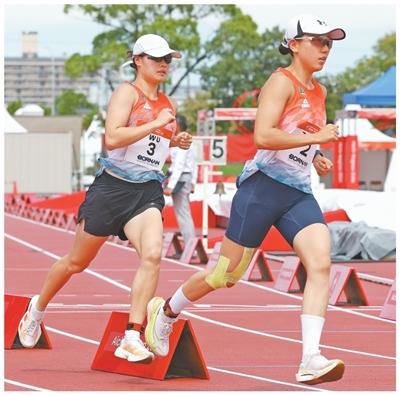 9月20日,中国队选手张明煜(右)、吴希瑶在现代五项女子团体项目激光跑比赛中。新华社记者 姚琪琳摄