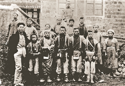 一九三六年二月,红六军团政委王震(前排左一)在贵州毕节与当地苗族群众合影。