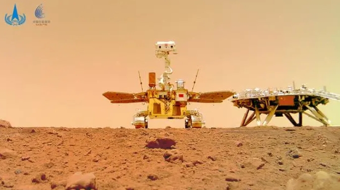 2021年6月11日，国家航天局在北京举行天问一号探测器着陆火星首批科学影像图揭幕仪式，公布了由祝融号火星车拍摄的着陆点全景、火星地形地貌、“中国印迹”和“着巡合影”等影像图。这是“着巡合影”图。新华社发（国家航天局供图）