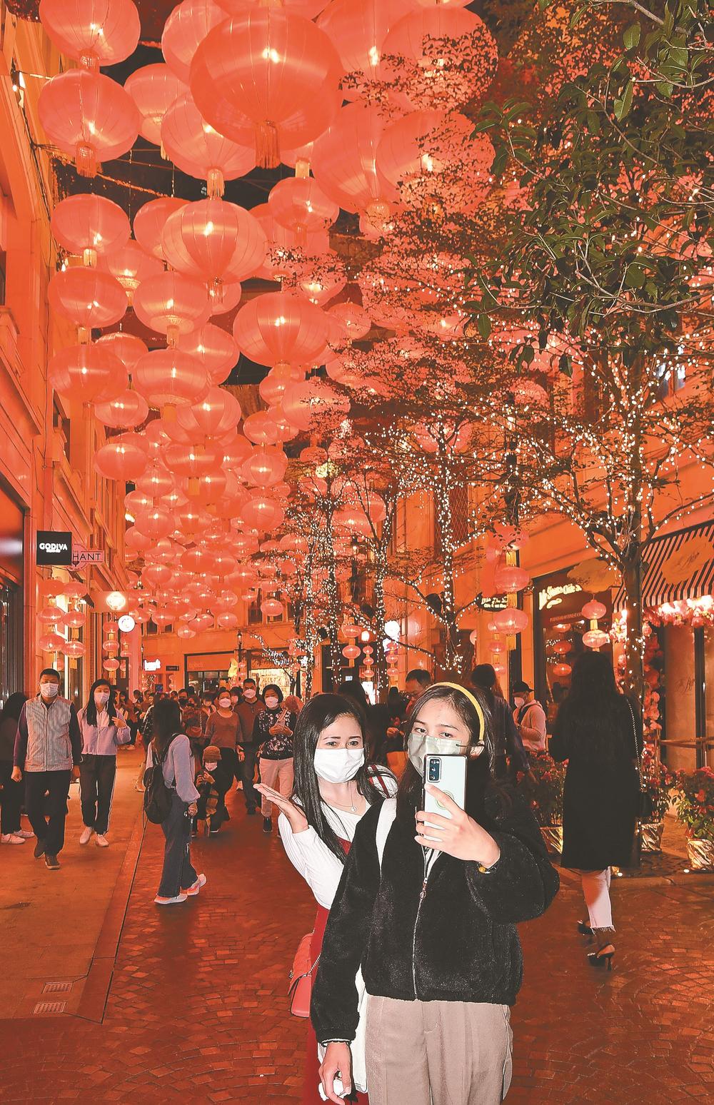 1月22日，人们在挂满红灯笼的香港利东街观光。新华社发