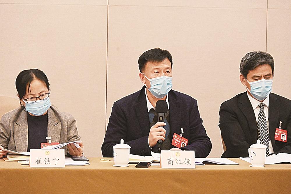 图①为商红领委员(右)就教育均衡发展问题建言。 贾宁 摄
