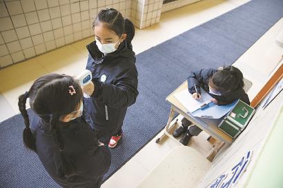 学生在测量体温,登记健康信息。