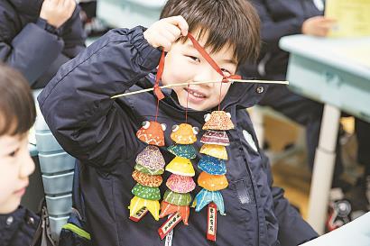 一名学生在教室里展示手工作品。