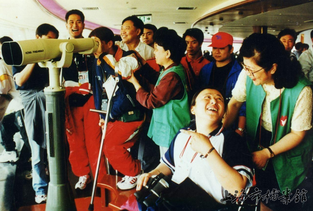 2000年，志愿者幫助殘障人士登上東方明珠塔（上海市檔案館藏）