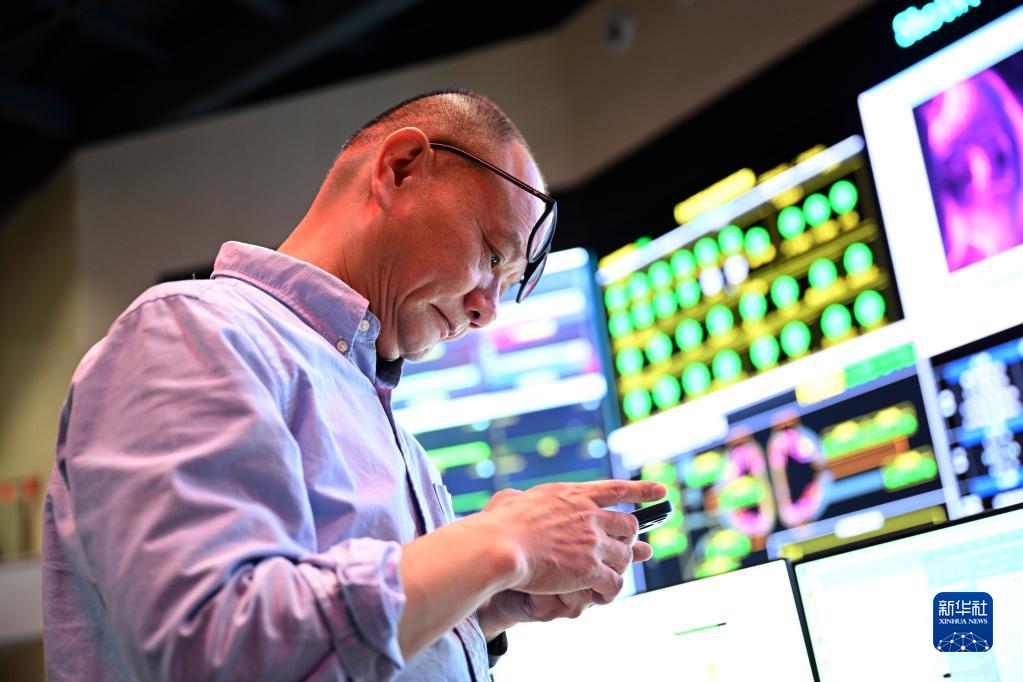 4月12日，在全超导托卡马克核聚变实验装置（EAST）控制大厅，EAST物理实验总负责人龚先祖在实验成功后向好友发消息庆祝。新华社记者 黄博涵 摄