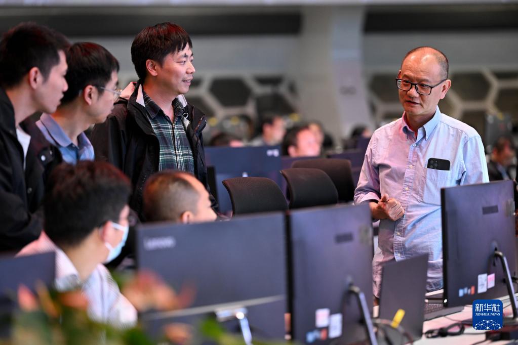 4月12日，在全超导托卡马克核聚变实验装置（EAST）控制大厅，EAST物理实验总负责人龚先祖（右一）在一次冲击实验后与同事交流。新华社记者 黄博涵 摄