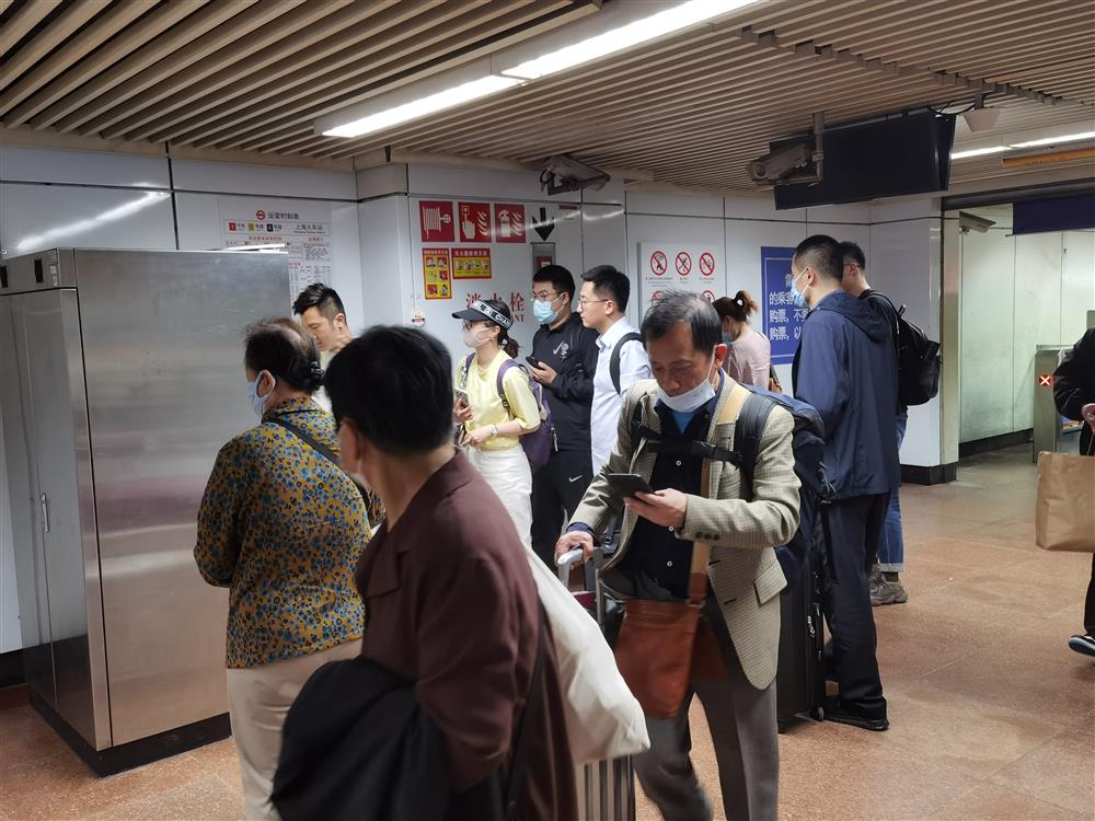自动售票机前，有乘客长时间未能完成购票，排队买票的队伍超出了排队区域，极易造成通道的堵塞。双方均为此准备了诸多措施。