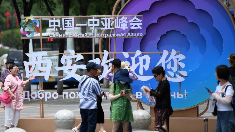 5月16日，游客在西安市北大街上与中国-中亚峰会主题装置合影。新华社 图