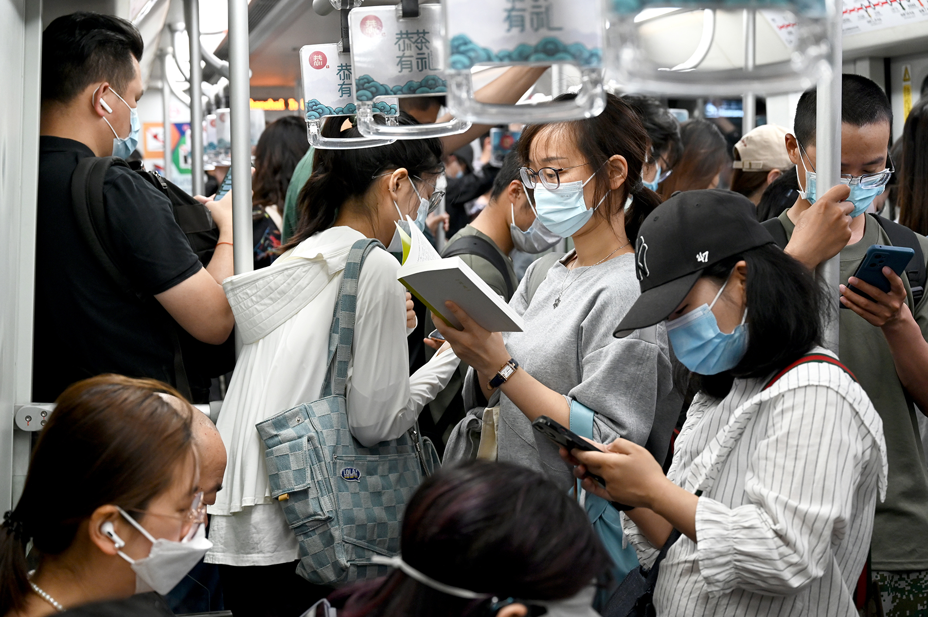 2023年5月25日，上海，地铁上一位正在看书的女子。澎湃新闻记者 吴栋 图