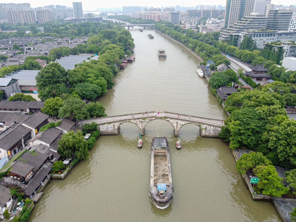 行驶在大运河上的货船通过杭州拱宸桥（2022年5月27日摄，无人机照片）。新华社记者 江汉 摄