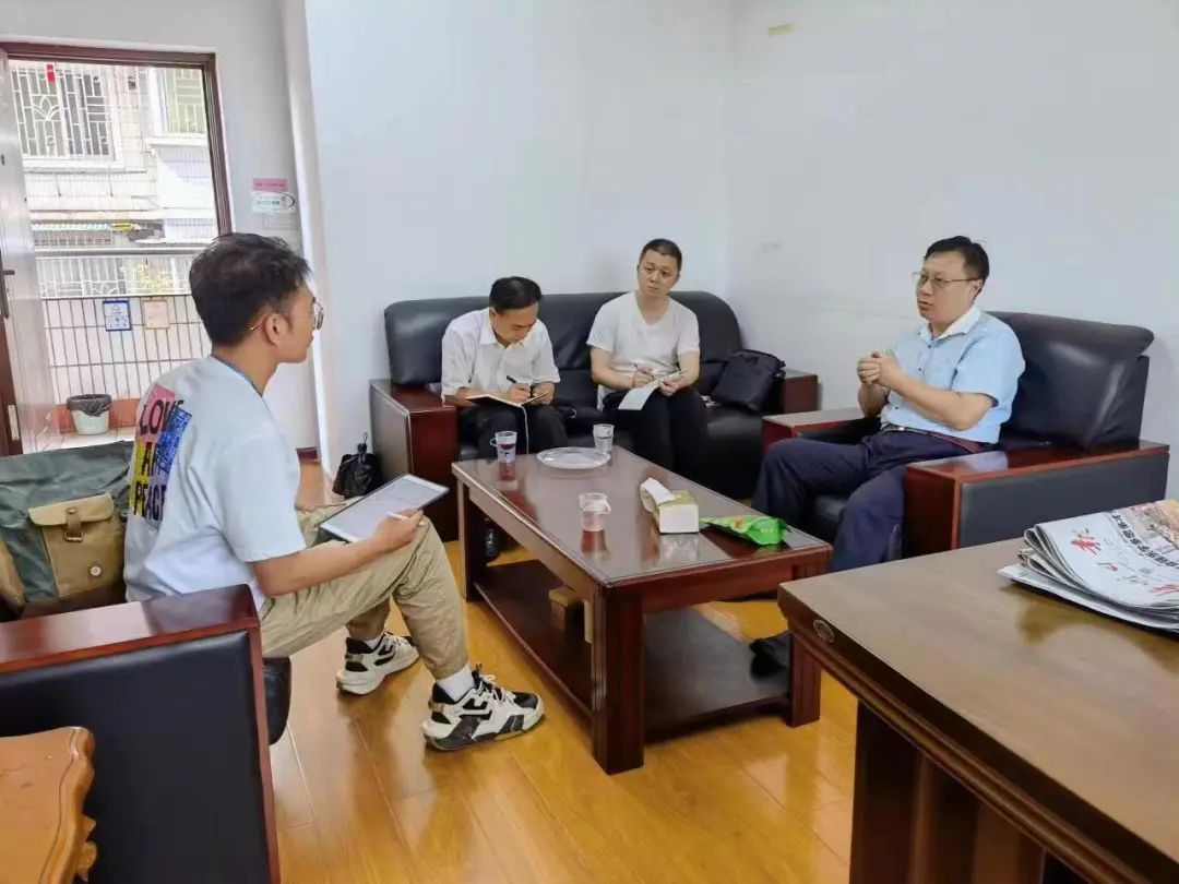 2022年6月1日,市政协委员韦放(右一)和梧州日报记者陈业漾(左一)就行人乱穿斑马线现象频发的问题进行讨论。(梧州市政协供图)