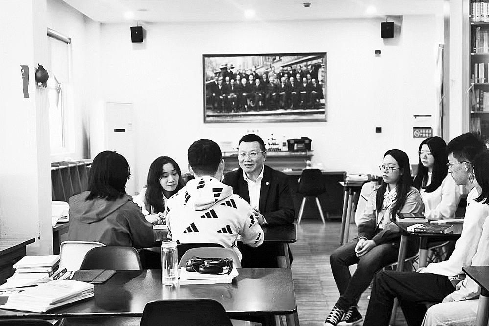 图为汪小帆委员(右一)前往学生社区,与上海大学钱伟长学院学生深入交流。