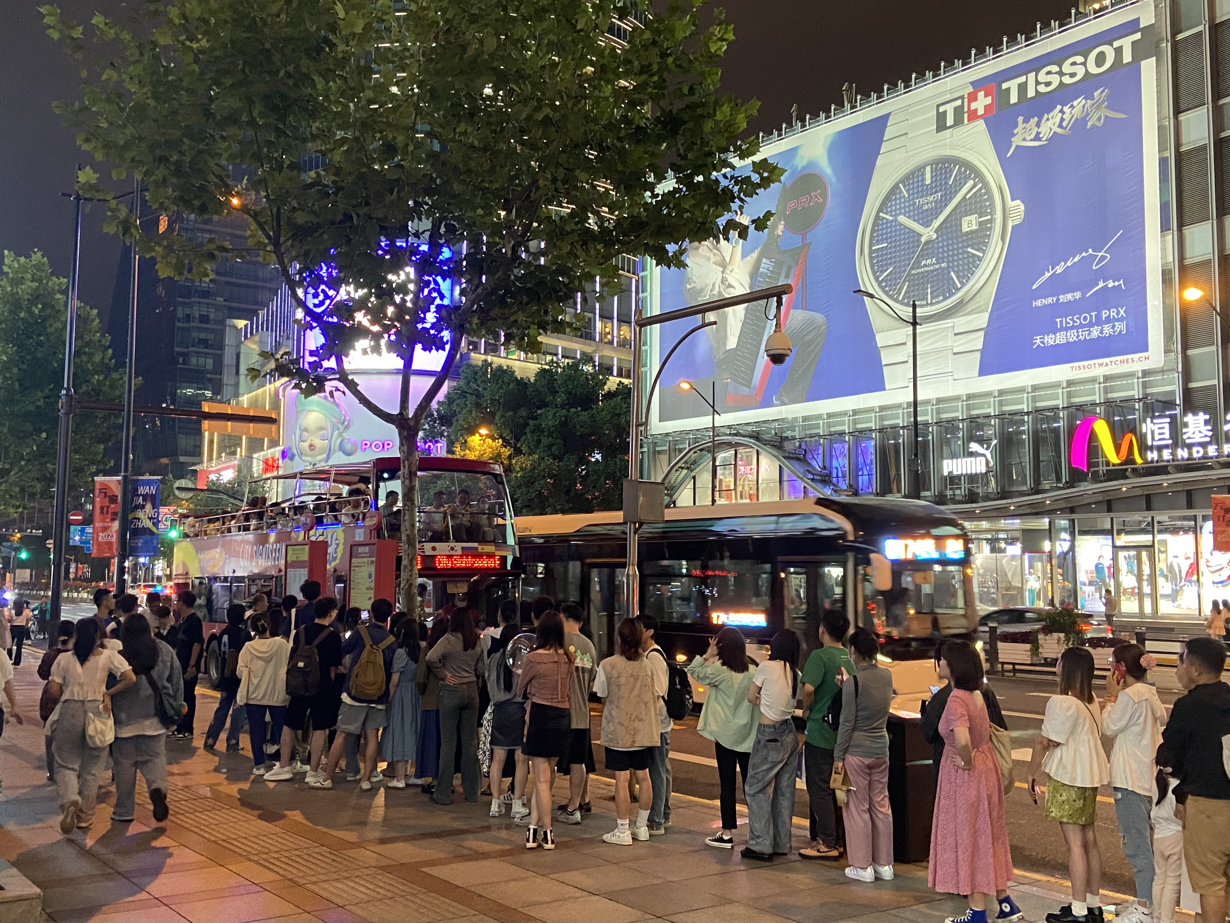 南京路步行街东侧,人们排队等待敞篷巴士。