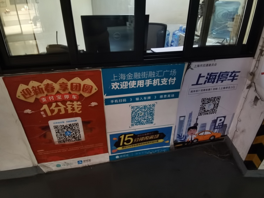 △万航渡路800号金融街汇融广场停车库的出入口处，张贴有大幅的“智慧停车”二维码海报。停车场库进驻“上海停车”平台后，采取的是“上海停车”平台与停车场库自有平台并行的管理模式。
