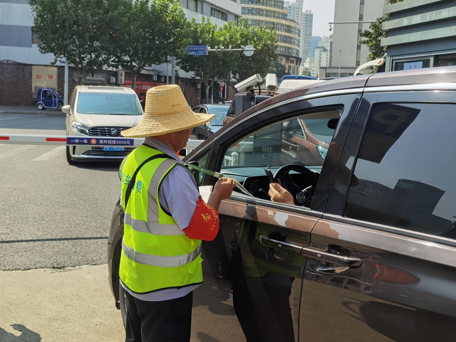 △上海火车站西南出口处的一处地面停车场内，车主正在扫描管理员的收费二维码付费。管理员称，通过“上海停车”平台付费，偶有信息不同步的现象。