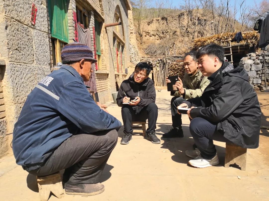 人民日报记者周亚军(右一)在山西平顺县西沟村,采访村民路伟力。郭雪岗摄