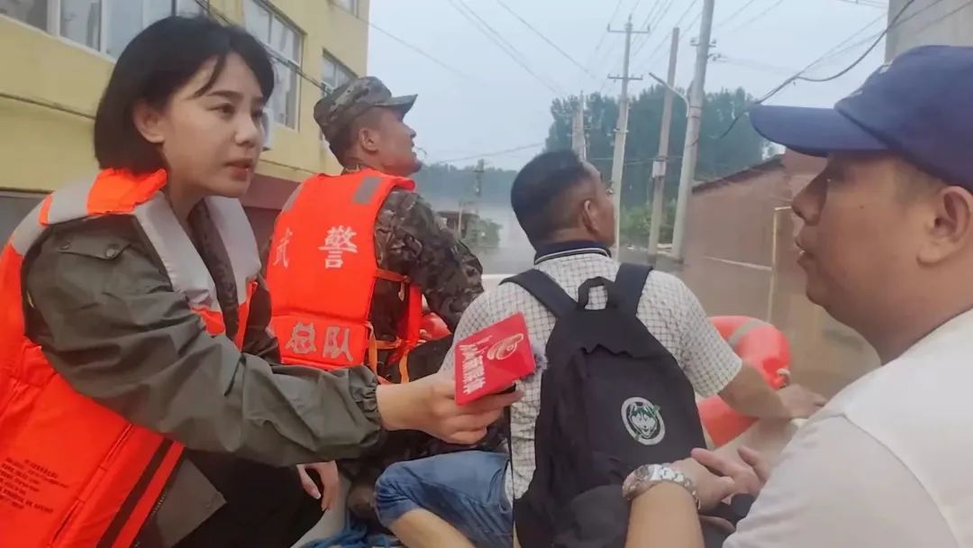2023年8月2日,长城新媒体记者张谢雅(左一)跟随武警河北总队机动支队官兵乘坐冲锋舟,进入涿州市卢家场村展开救援采访。