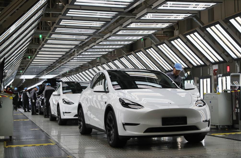2023年12月22日，在特斯拉上海超级工厂内，工人在对出厂前的车辆进行漆面及门窗检测。新华社记者方喆摄