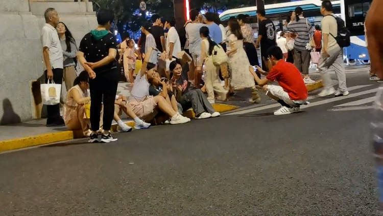 很多游客累了就坐在九江路路边