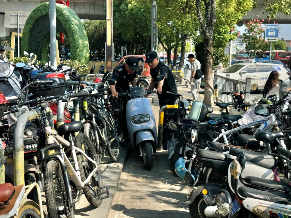 上海松江区泗泾地铁站东侧外的一个非机动车停车点,现场秩序维护员正将违停车辆挪位。 澎湃新闻记者 邹桥 图