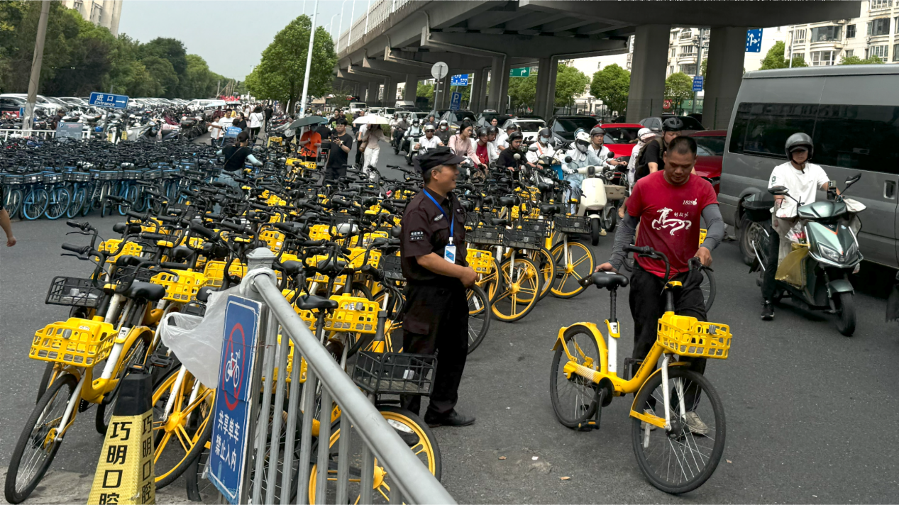松江区九亭地铁站西侧,共享单车堆集,运维车辆停靠,非机动车道被占据。澎湃新闻记者 邹桥 图