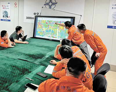 科研人员在研究“梦想”号设计图纸。广州海洋地质调查局供图