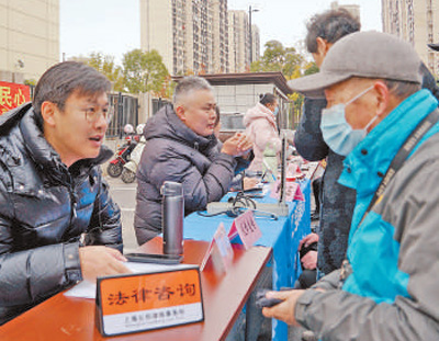 宝山区新顾城大居拓展区联合党支部开展便民服务活动。图为工作人员为居民提供法律咨询。<BR/>马伟勤摄