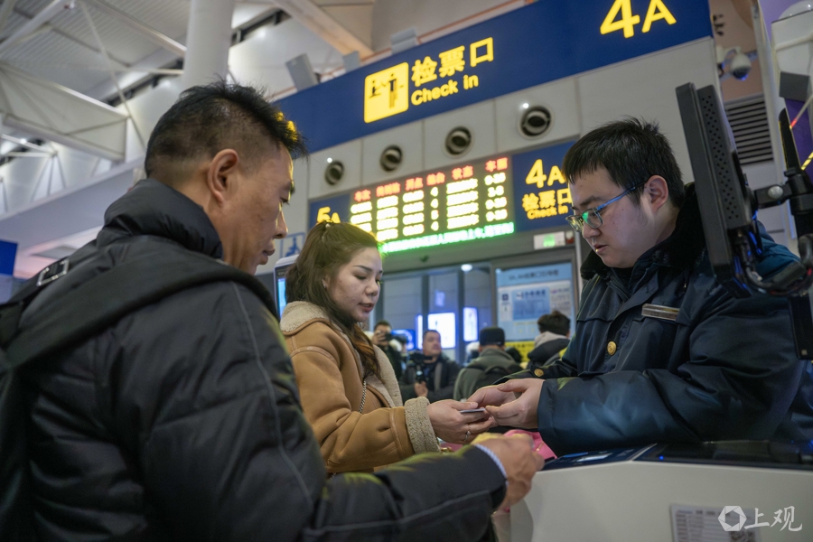 工作人员为现场不能出示身份证的旅客进行人工检票。