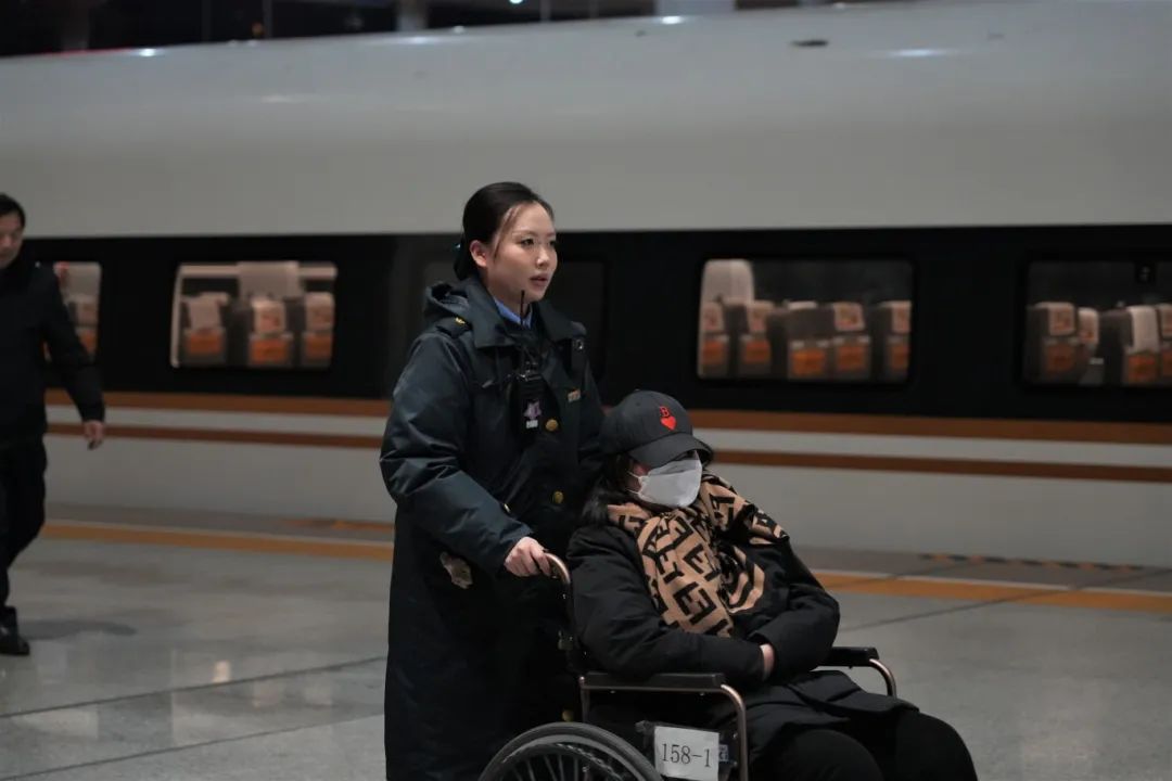 1月21日凌晨,南京南站“158”雷锋服务站工作人员服务重点旅客出站。魏宁波 摄