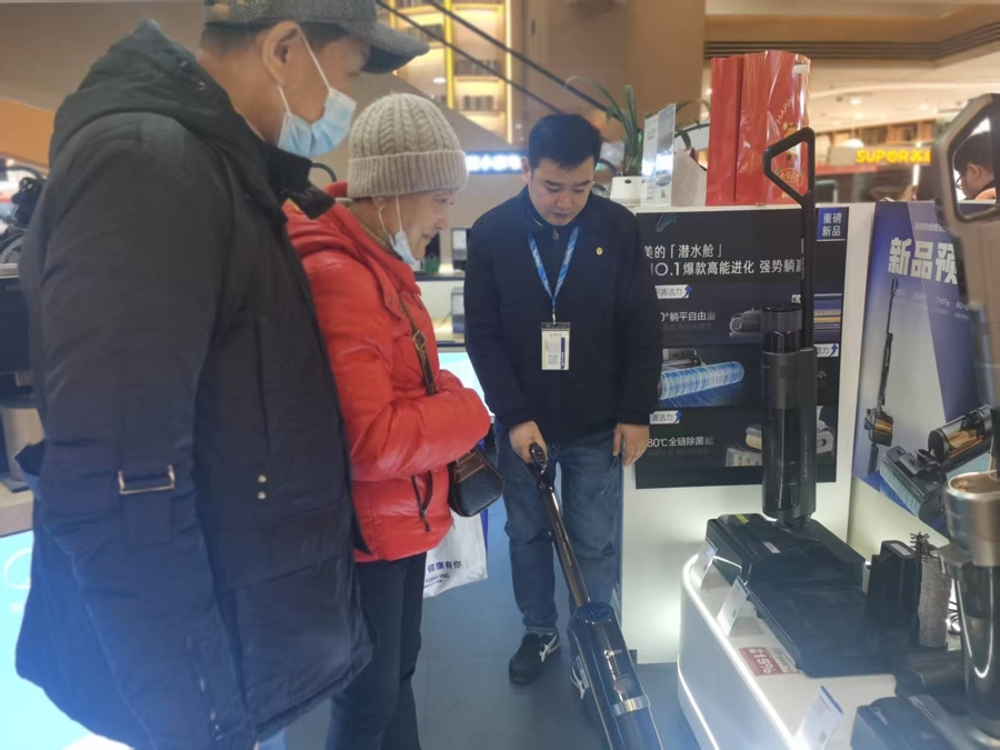 苏宁五角场店的美的柜台,营业员向顾客介绍加入“市补”的洗地机商品。
