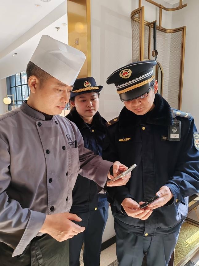 优化涉企监管检查,一张“检查码”发挥了大作用。图为商户扫描“检查码”,明确的信息让餐馆负责人心里有了数。实习生 朱佳佳 澎湃新闻记者 邹娟 图