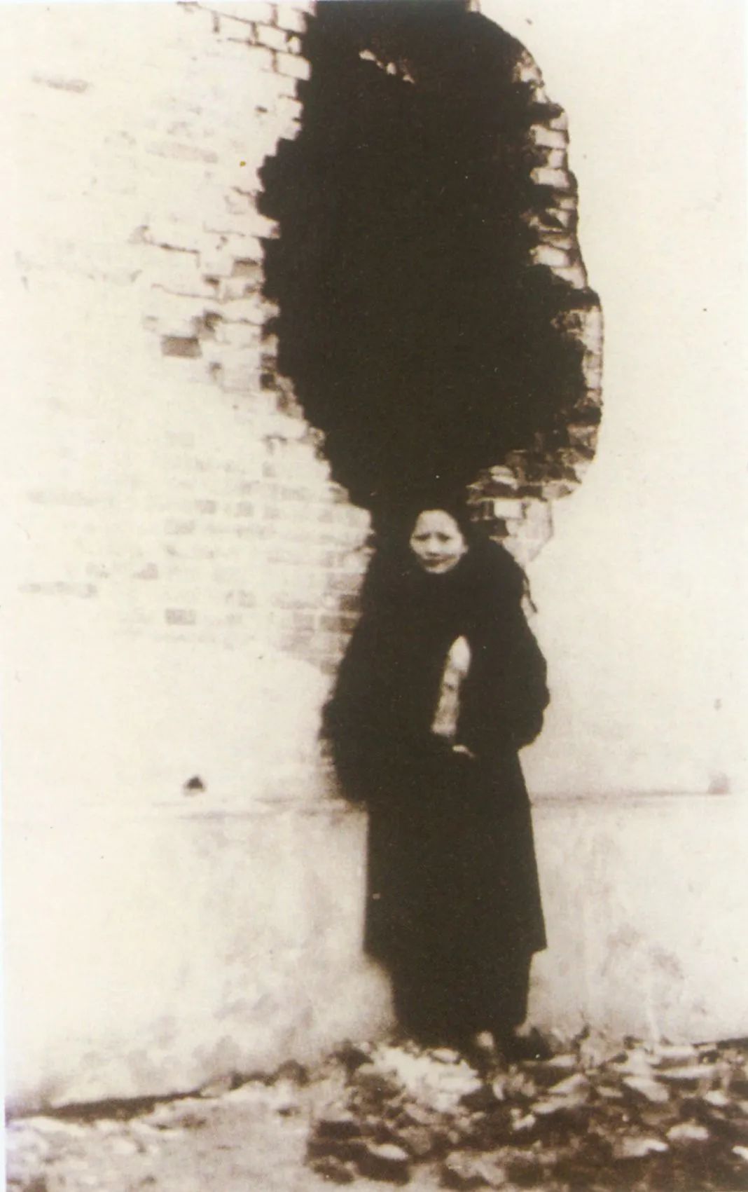 1932年2月6日,宋庆龄在真如前线断垣边,手持未爆炸的敌弹留影,表示抗战到底的决心
