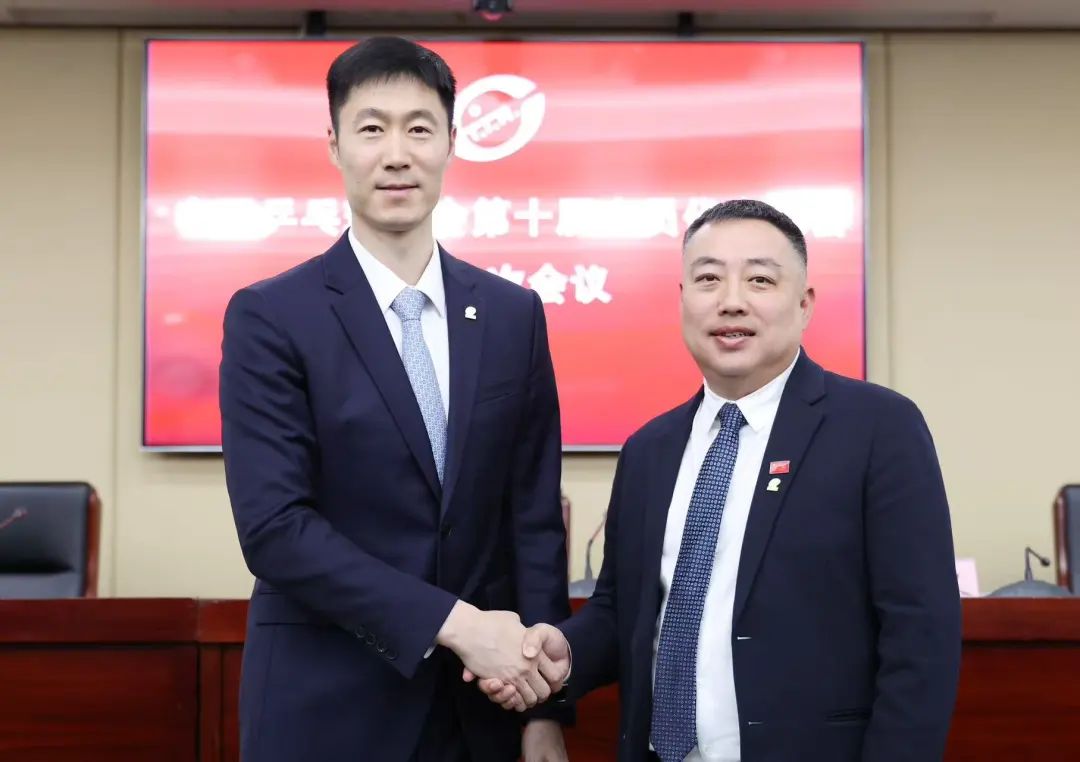 王励勤(左)与刘国梁握手致意。