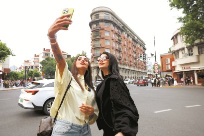 昨天,阿联酋网络达人Sara Al Madani(左)和朋友在武康大楼前合影。 记者 李茂君 摄