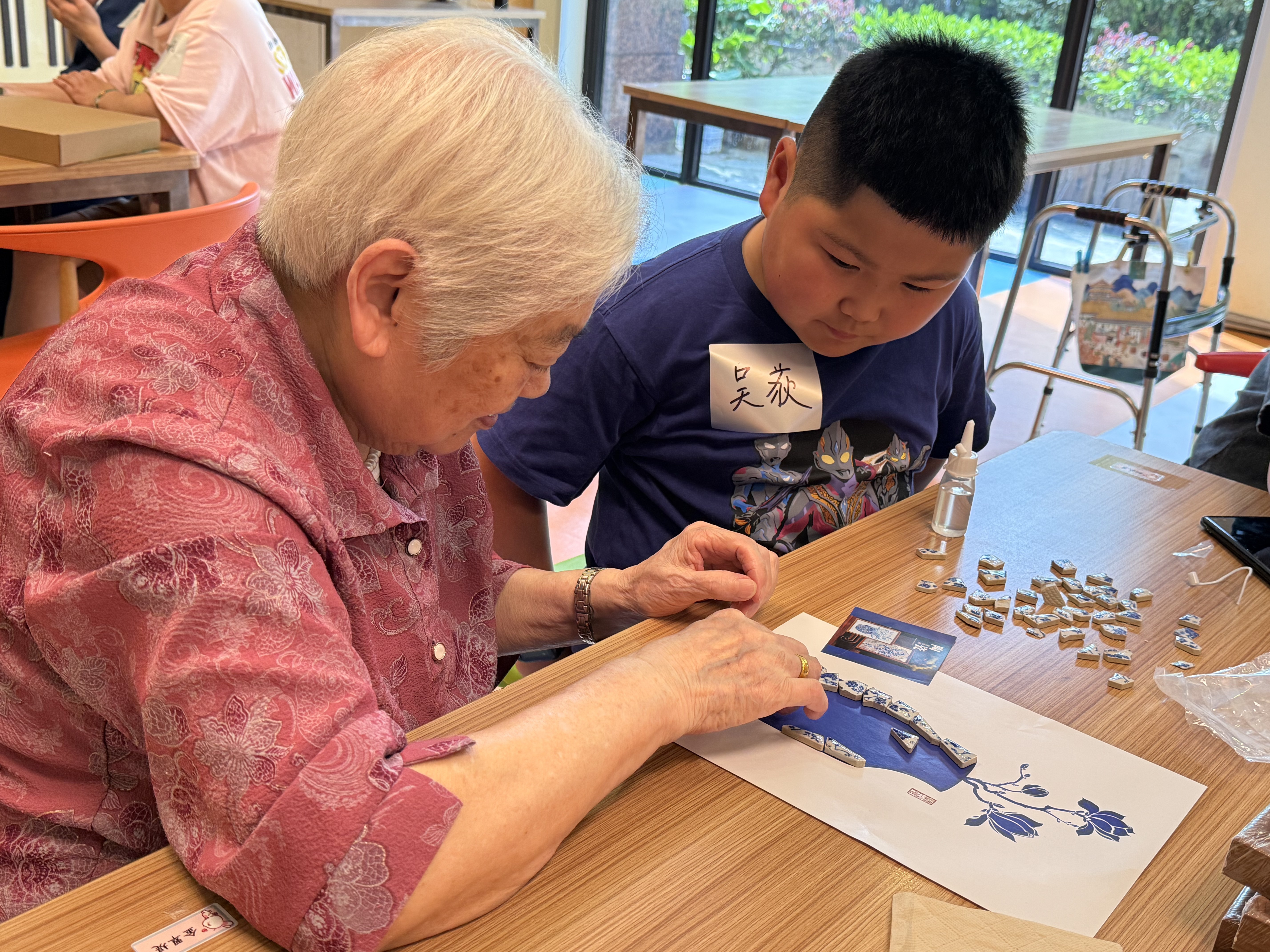 孩子在陪伴老人制作陶瓷画
