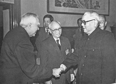 全国政协七届一次会议期间,时任全国政协主席李先念与时任全国政协副主席、民建中央咨议委员会主任孙晓村握手,中为时任全国政协副主席刘靖基。