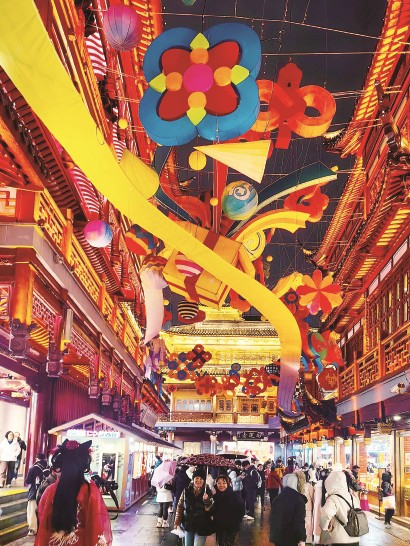 昨天，豫园商城里新年气氛渐浓，不少中外游客冒着小雨观赏夜幕下初露端倪的马年新春民俗灯会。 视觉中国